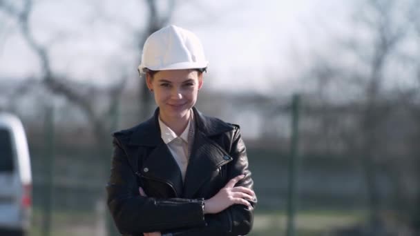 Aantrekkelijke jonge vrouw in beschermende helm, glimlachen en kijken naar de camera — Stockvideo