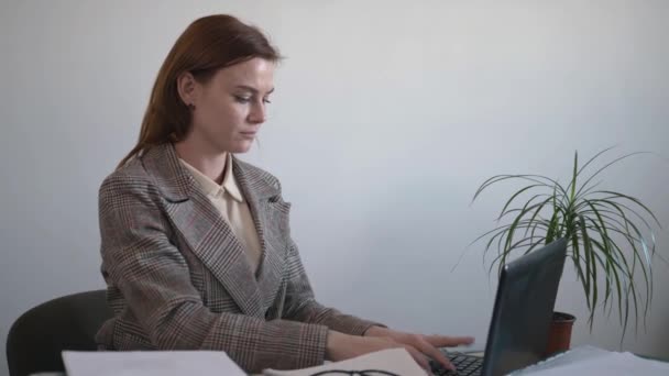 Mujer molesta siente dolor de espalda mientras masajea el dolor muscular, empleado mujer triste sufre de dolor de espalda baja sentado en la posición incorrecta sentado, trabajando en la computadora en la oficina, radiculitis — Vídeo de stock