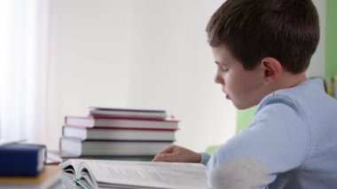 Çocuk gelişimi, akıllı çocuk ilginç bir kitap sayfasını okurken parmağını kaydırıyor.