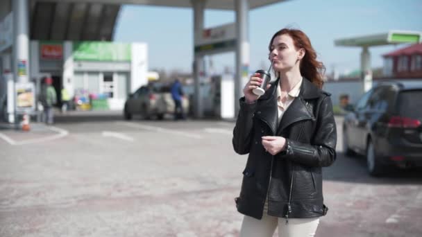 Livsstil, kvinnliga förare ler från priset på bensin leenden och dricker kaffe med henne medan bilen tankning på bensinstationen på väg till jobbet, kundservice — Stockvideo