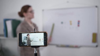 Çevrimiçi eğitim, modern bayan öğretmen karantina sırasında cep telefonunda video iletişimi ve izolasyon yoluyla uzaklık öğrenme modunda genç öğrencilere matematik dersleri veriyor
