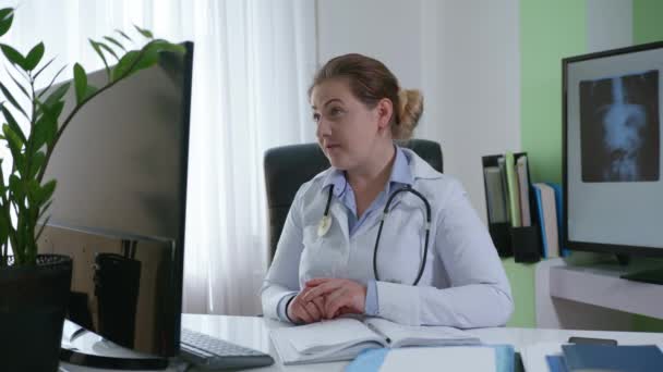 Medico donna con fonendoscopio parlando guardando webcam fornire assistenza remota in chat virtuale, medico operaio videochiamata consulenza paziente online — Video Stock