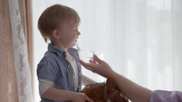 Water balans, kleine schattige jongen wil niet zuiver water te drinken in glas — Stockvideo