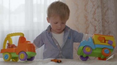Güzel, mutlu, mutlu, sinir sistemi iyi ve sağlıklı bir erkek çocuk. Plastik renkli oyuncaklarla iyi eğlenceler.