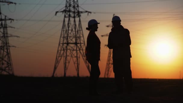 Equipe de engenheiros apertar as mãos na reunião e discutir a construção de uma nova linha elétrica, silhueta — Vídeo de Stock