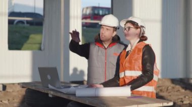 Endüstriyel, mimar ve mühendis, hangardaki inşaat alanında yeni proje ve çizimler üzerinde çalışıyor