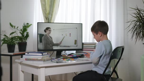 Μάθηση σε απευθείας σύνδεση, μαθητής του δημοτικού σχολείου παιδιών διδάσκει μαθήματα με το δάσκαλο για την επικοινωνία βίντεο χρησιμοποιώντας σύγχρονες τεχνολογίες που κάθονται στο σπίτι — Αρχείο Βίντεο