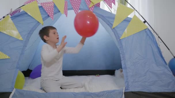 Schattig gelukkig mannelijk kind veel plezier spelen wigwam ballon — Stockvideo