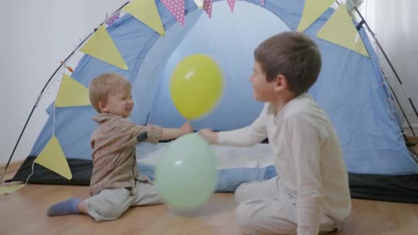 Leuke spelletjes, vrolijke vriendelijke broers genieten van tijd doorbrengen samen ballonnen spelen — Stockvideo