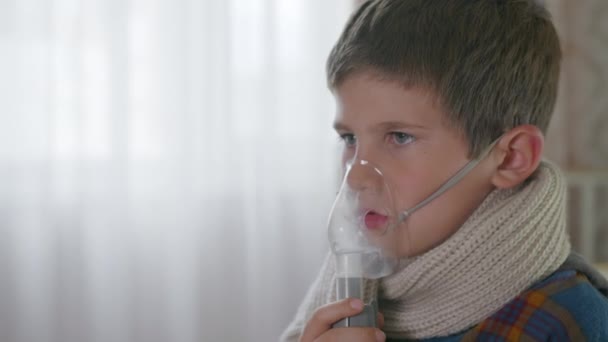 Pandemia, uma pequena criança do sexo masculino bonito não está se sentindo bem, começa a partir da tosse ou respiração, usa um nebulizador — Vídeo de Stock