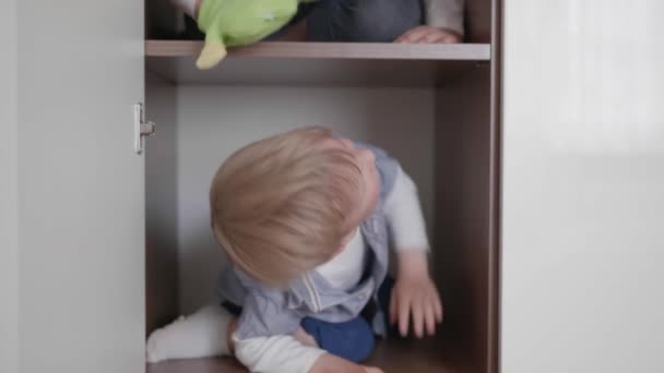 Casa, alegre pouco amigável irmãos gostam de passar o tempo juntos e se divertir jogando no armário no quarto — Vídeo de Stock