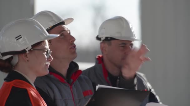 Bauingenieur diskutiert auf Baustelle mit Architekt und Designer über Neubauprojekt — Stockvideo