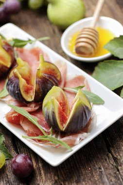  Beyaz bir plaka üzerinde jambon ile taze incir