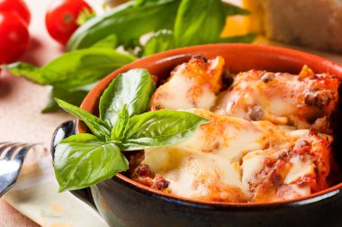 fesleğen ile beyaz bir kapta taze lazanya