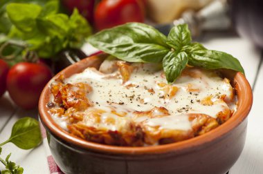 fesleğen ile beyaz bir kapta taze lazanya