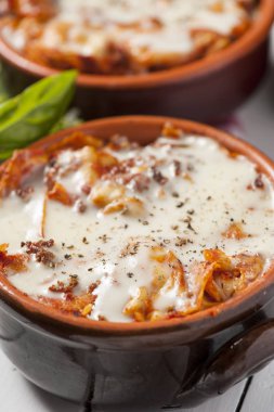 fesleğen ile beyaz bir kapta taze lazanya