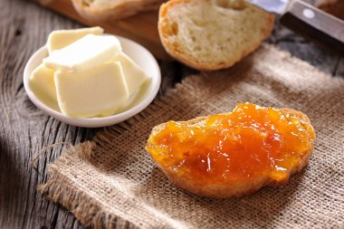 ekmek ve ahşap masa üzerinde turuncu ev yapımı reçel