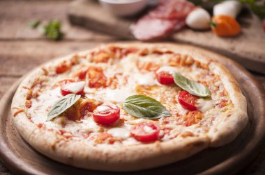 Mozzarella, peynir ve fesleğen yapraklı kırsal İtalyan pizzası.