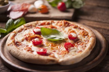 Mozzarella, peynir ve fesleğen yapraklı kırsal İtalyan pizzası.
