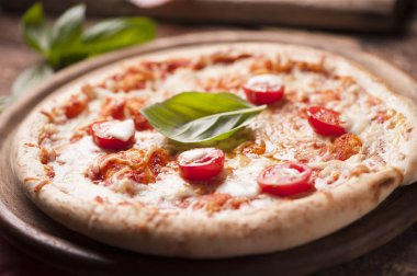 Mozzarella, peynir ve fesleğen yapraklı kırsal İtalyan pizzası.