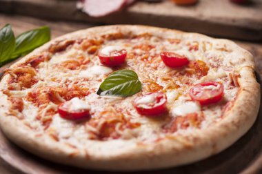 Mozzarella, peynir ve fesleğen yapraklı kırsal İtalyan pizzası.