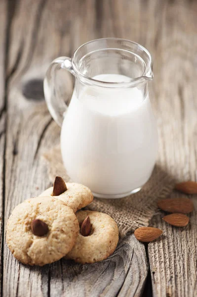 Biscotti integrali con mandorle e un barattolo di latte — Foto Stock