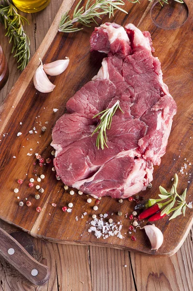 Carne de romero en rodajas crudas sobre fondo de madera — Foto de Stock