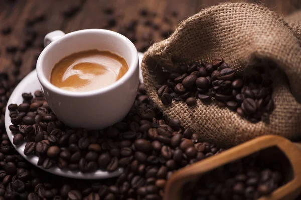 Koffie beker close-up over donkere gebrande koffiebonen — Stockfoto