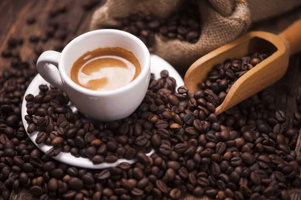 Koffie beker close-up over donkere gebrande koffiebonen — Stockfoto