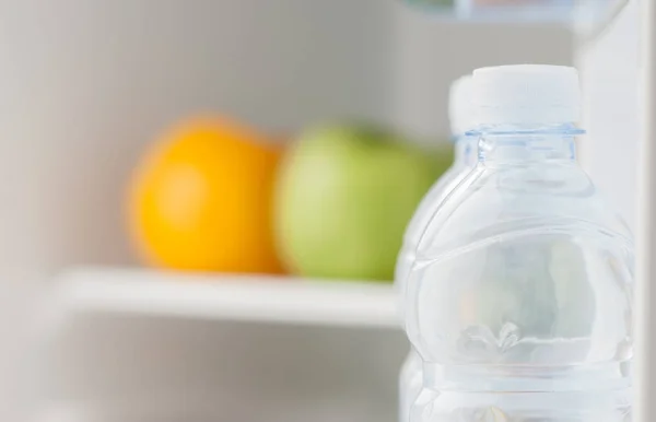 Bottles of cold and refreshing mineral water in refrigerator