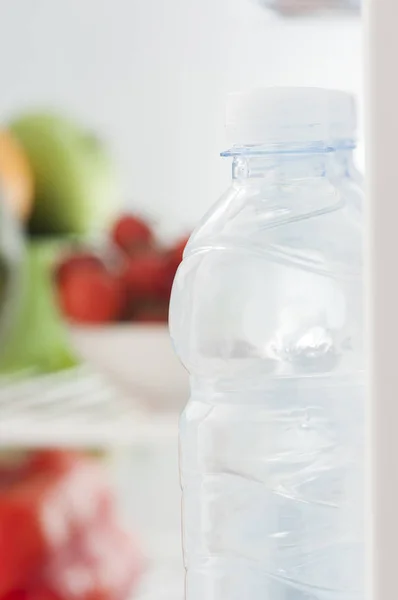 Bottles of cold and refreshing mineral water in refrigerator