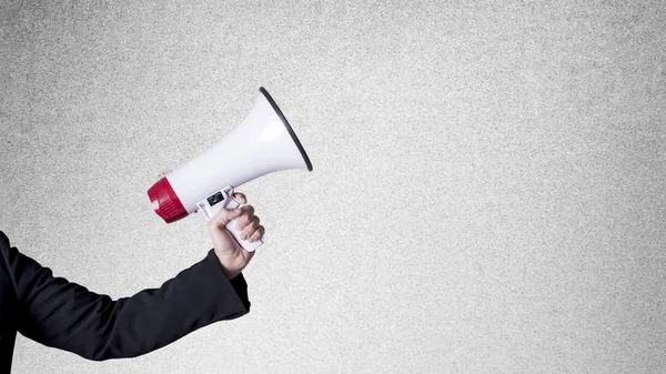 Close-up of human hand holding megaphone against blackboard — Stock Photo, Image