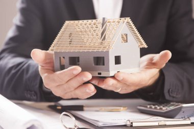 Model ev avucunun içinde tutan işadamı