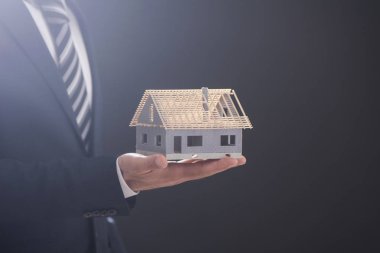 Model ev avucunun içinde tutan işadamı