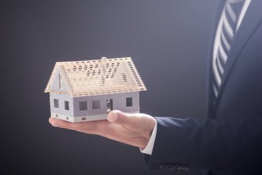 Model ev avucunun içinde tutan işadamı