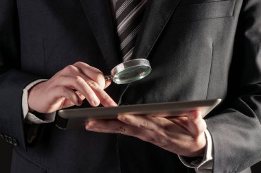  Büyüteç ve dijital tablet kavramı holding iş adamı