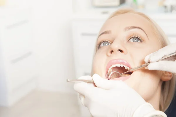 Closeup of female dentist examining mid adult patient