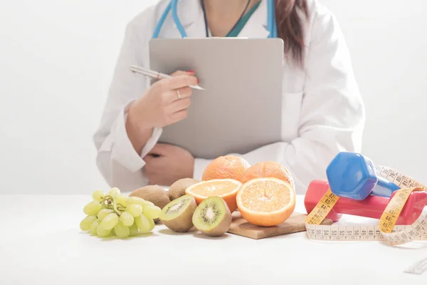 Médico nutricionista em sua mesa com frutas — Fotografia de Stock