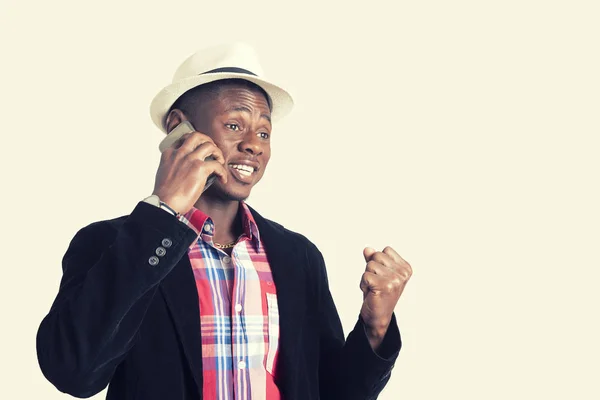 Портрет здивованого молодого африканського хлопця, який дивиться на мобільний телефон — стокове фото