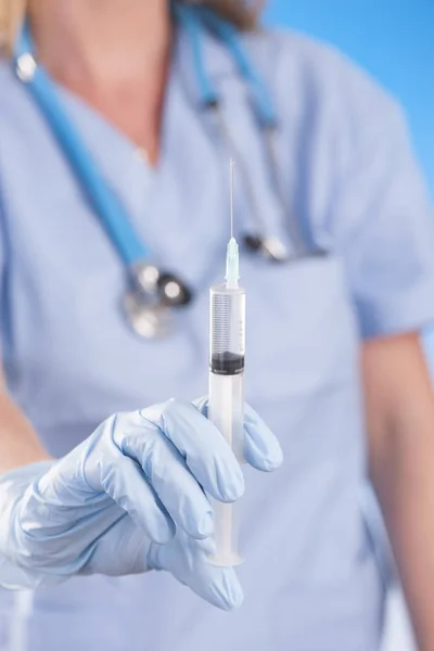 Arts holding medische injectiespuit en stethoscoop — Stockfoto