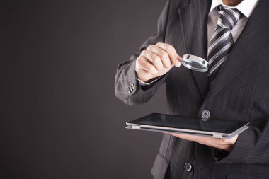 teknoloji, internet ve iş kavramı - Büyüteç tablet pc bilgisayar üzerinde tutan işadamı
