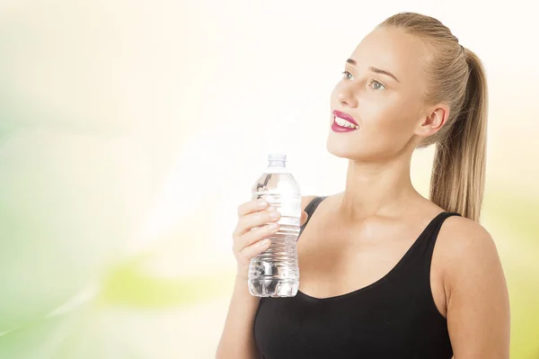 Jeune femme saine et sportive buvant de l'eau de la bouteille — Photo
