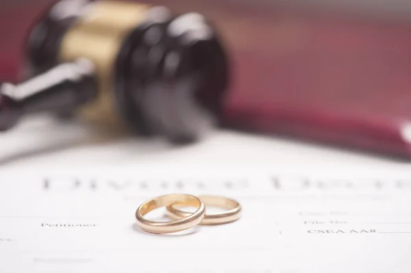 Свадебные кольца на документе с молотком — стоковое фото