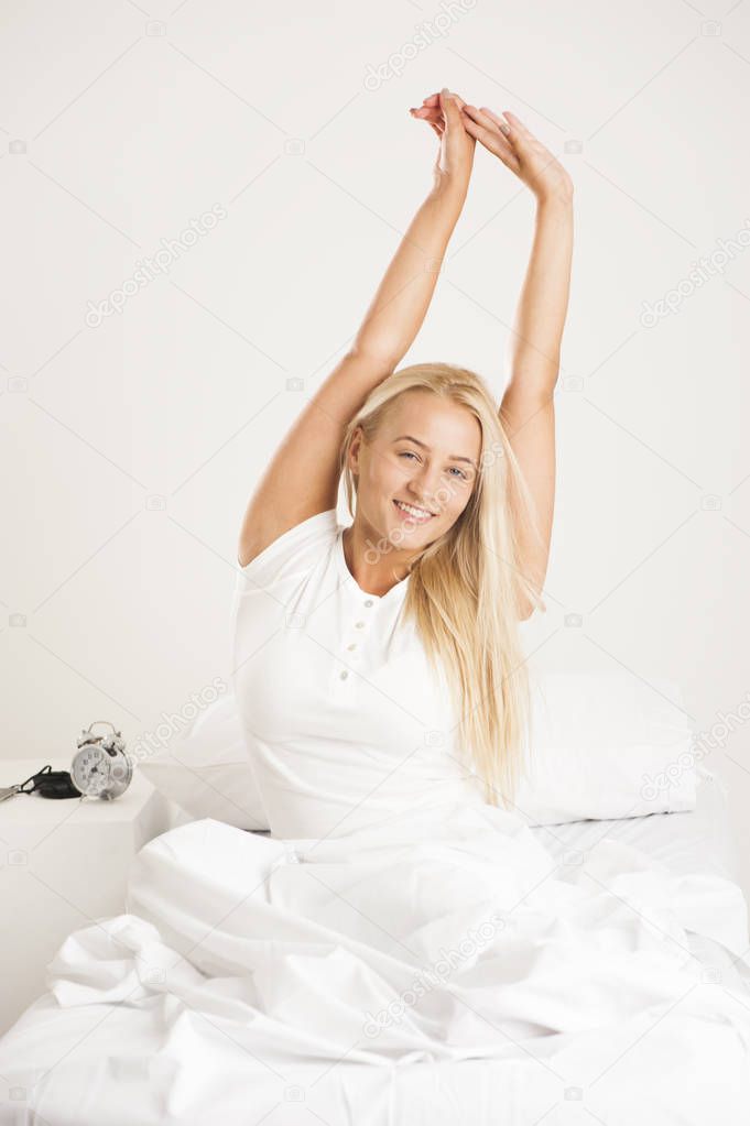 Young woman waking up at bedroom