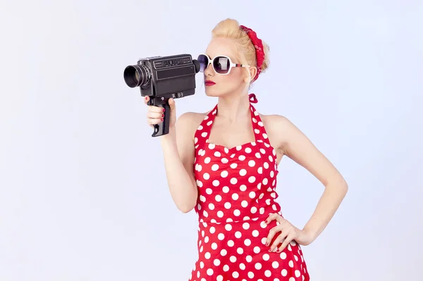 Pin-up girl shooting a movie with an old cinema 8 mm camera