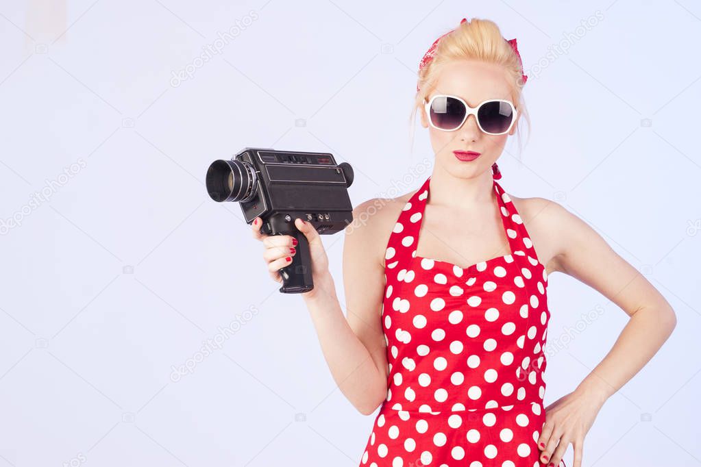 Pin-up girl holding vintage 8 mm camera