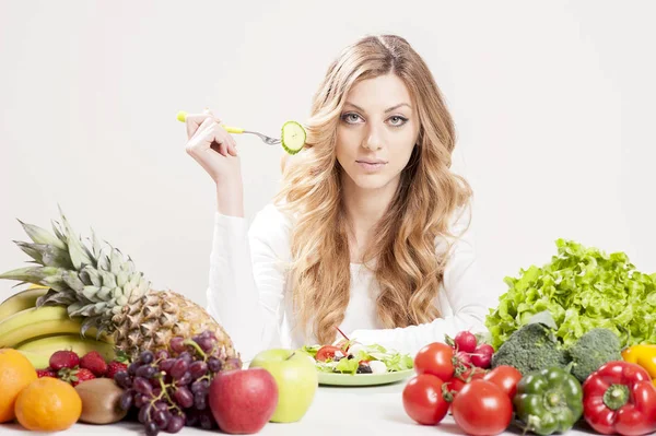 Donna mangiare insalata su uno sfondo bianco — Foto Stock