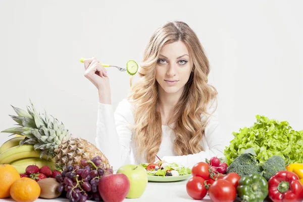 Женщина ест салат на белом фоне — стоковое фото