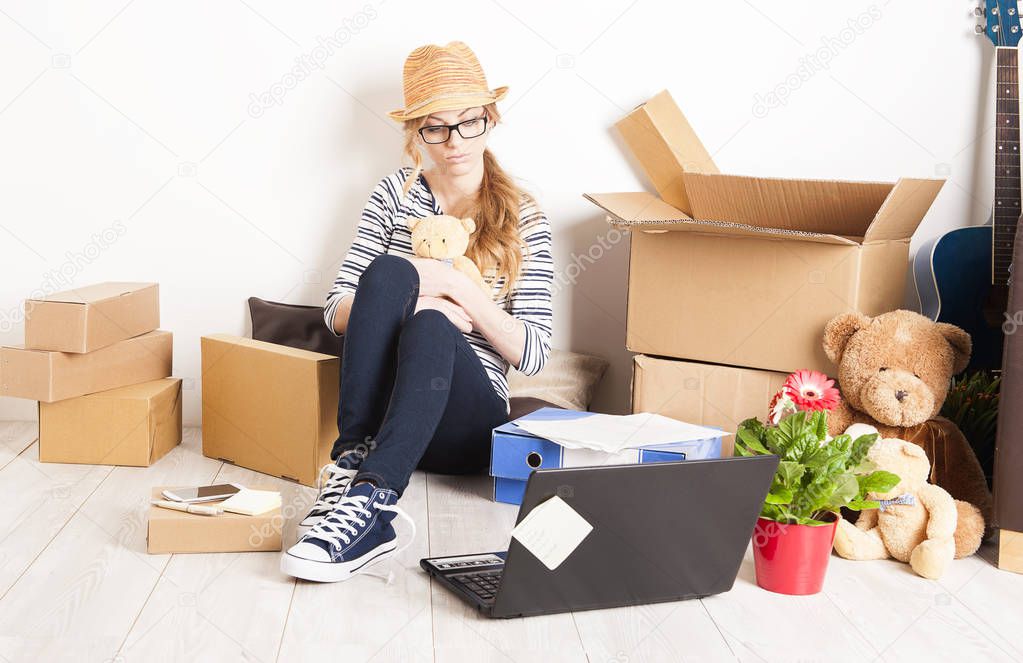 Young woman moving into new apartment house assembling furniture