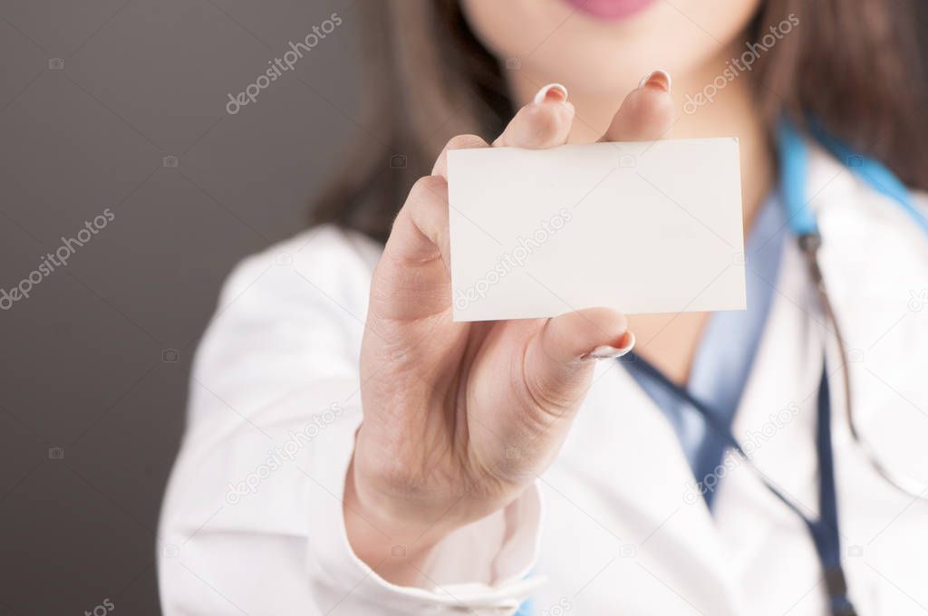 Close up of female doctor's hand showing blank business card 